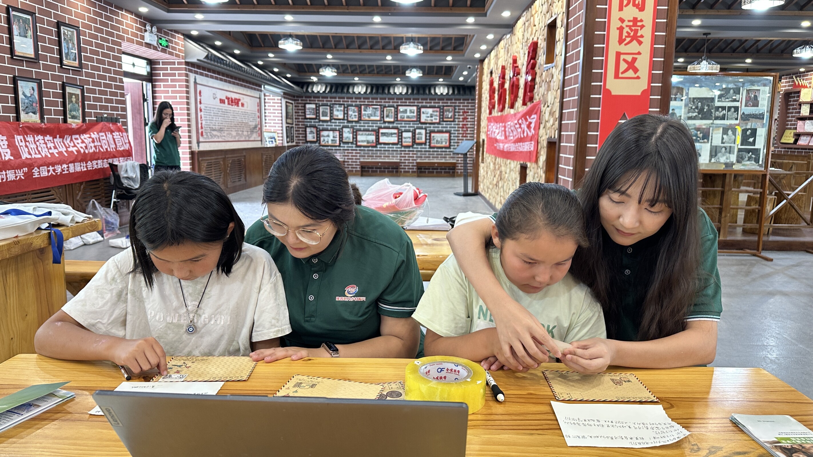 团队成员在红色书屋教小朋友写信.jpeg