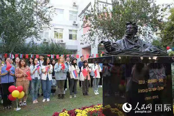 首都师范大学俄语系学生手持中俄两国国旗参与普希金雕像揭幕仪式（图片由首都师范大学提供）